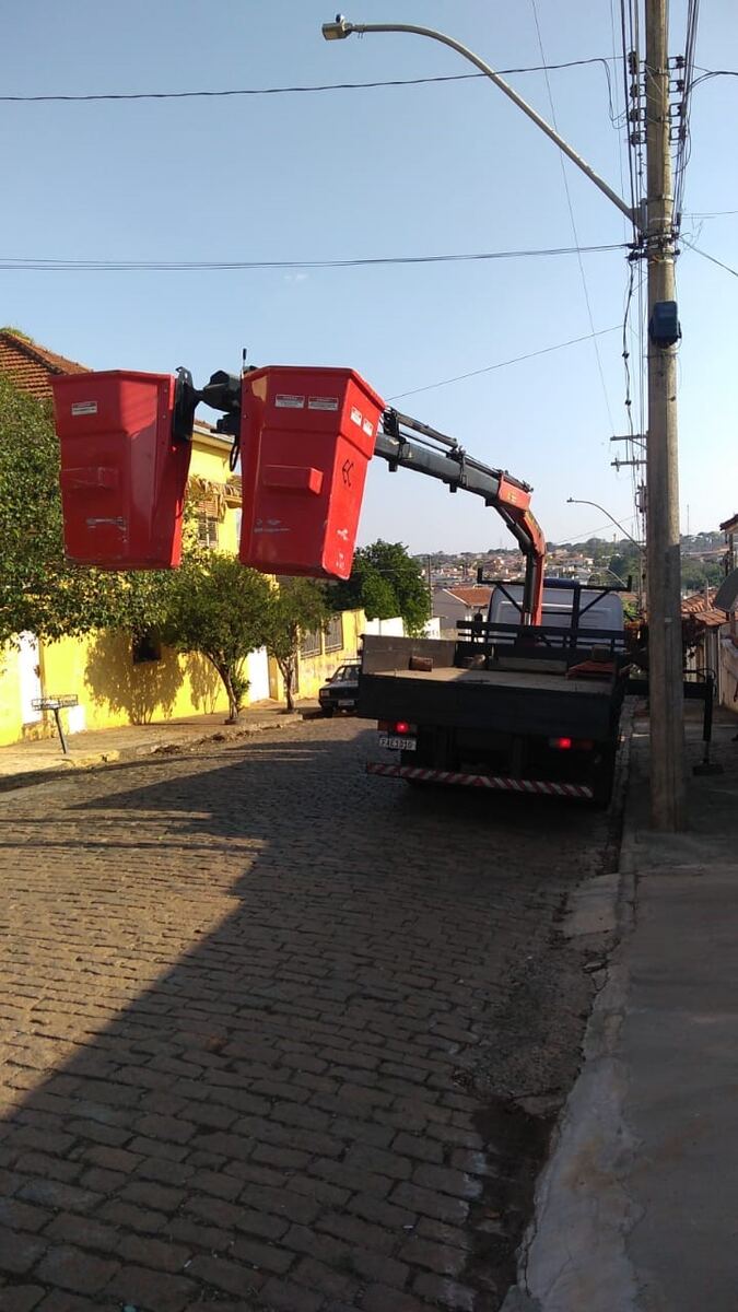 Caminhão munck da PROINT erguendo caçambas de trabalho em altura durante serviço em rede